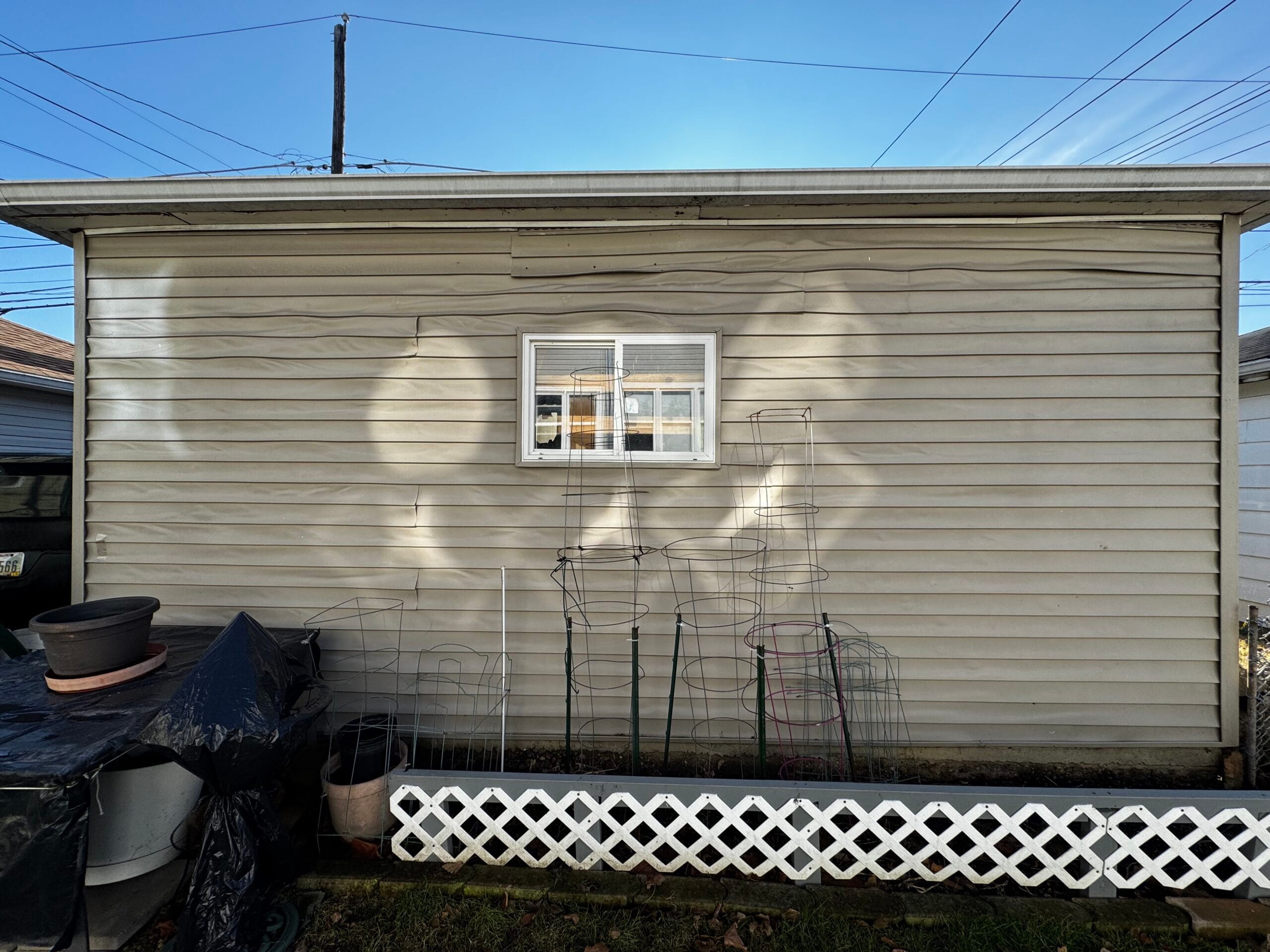 Melted vinyl siding on a house due to heat reflection from nearby windows.